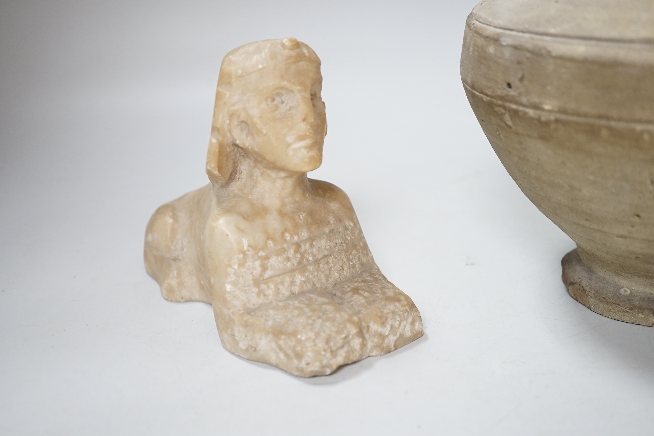 An Egyptian style alabaster model of a sphinx and a twin handled pottery vase, the largest 25cm high